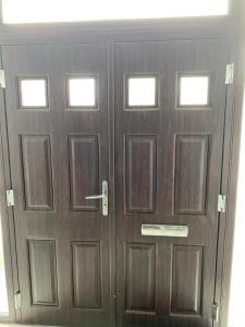 a pair of wooden doors in a room at Varditchi in Redbridge