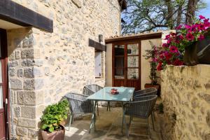 a patio with a table and chairs and flowers at Miradorio Rural Boutique Apto Tussio in Ruiloba +1 photo