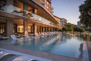 a hotel swimming pool with lounge chairs in front of a building at Amadria Park Grand Hotel 4 Opatijska Cvijeta in Opatija