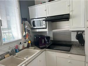 a kitchen with a sink and a microwave at Appart calme avec Parking privé, Métro 3min, 12min Paris in Boulogne-Billancourt