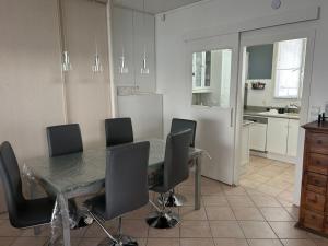 a dining room table with chairs and a kitchen at Appart calme avec Parking privé, Métro 3min, 12min Paris in Boulogne-Billancourt