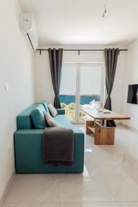 Una sala de estar con un sofá azul y una mesa. en Elia apartments, en Ražanj