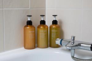 tre bottiglie di acqua dolce sedute su un lavandino del bagno di Charming Isle of Skye Holiday Cottage, Glendale a Glendale Altre 72 foto