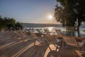 a row of chairs sitting next to a body of water at Amadria Park Grand Hotel 4 Opatijska Cvijeta in Opatija