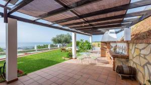 a patio with a fireplace and a view of the ocean at Villa en Lagos Bajo Vélez-Málaga by Ruralidays in Vélez-Málaga