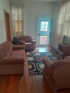 a living room with two couches and a rug at Apartments 145 in Georgetown