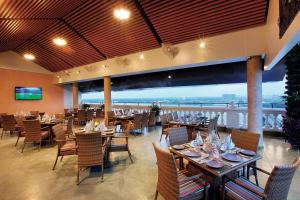 a dining room with tables and chairs with a view at Le Maritime Kochi in Cochin