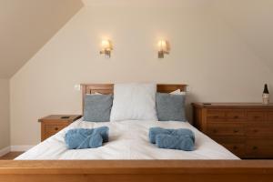 una camera da letto con un letto con due asciugamani blu sopra di Charming Isle of Skye Holiday Cottage, Glendale a Glendale