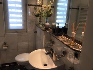 a bathroom with a sink and a toilet and a mirror at Messewohnung Düsseldorf in Düsseldorf +20 photos