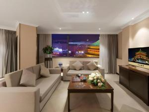Una sala de estar con un sofá y un televisor. en Bell Tower Hotel, en Xi'an