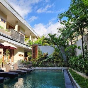 a swimming pool in front of a building at Olivia Guest House Canggu in Canggu