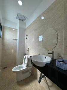 une salle de bain avec toilettes, lavabo et miroir dans l'établissement GIA BẢO TÂY ĐÔ 3 Hotel, à Ấp Bình Thương