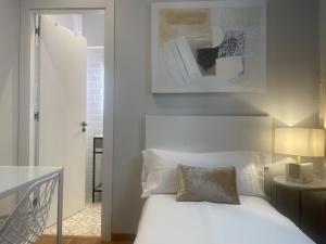 a bedroom with a white bed and a table at Des Artistes in Barcelona