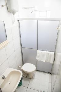 a bathroom with a toilet and a sink at Hotel Pinheirinho in Curitiba