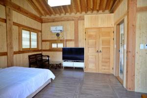 a bedroom with a bed and a flat screen tv at 홍성군 편백나무 남당한옥 in Hongseong