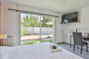 a bedroom with a bed and a desk and a window at La tranquilité bleue - Maison avec Parking cloturé in Les Sables-dʼOlonne