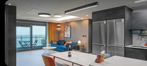 a kitchen with a table and a living room at 오시리아 해운대 in Busan