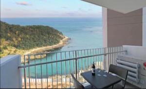 a balcony with a table and a view of the ocean at 오시리아 해운대 in Busan