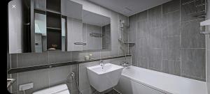 a bathroom with a sink and a toilet and a tub at 오시리아 해운대 in Busan
