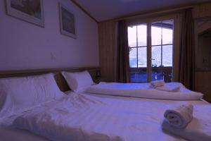 Postel nebo postele na pokoji v ubytování Hotel Wildbach Brienz