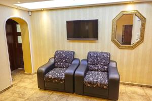 a room with two chairs and a tv on a wall at Villa Katalina in Varna City