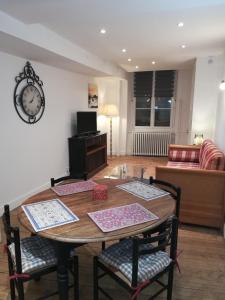 a living room with a table and chairs and a couch at La Manufacture in La Tour-du-Pin