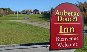 a sign for an envelope doubt inn in a golf course at Auberge Doucet Inn in Chéticamp
