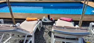 two chairs and a table next to a swimming pool at Owl's Nest in Bar