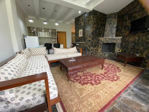 a living room with couches and a fireplace at Mount Vista Resort in Murree
