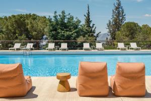 a group of chairs sitting next to a swimming pool at Amalia Hotel Delphi in Delphi