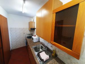 a small kitchen with a sink and a microwave at Ca Blanca Rooms in Marsiai