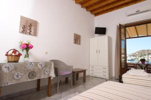 a bedroom with a bed and a desk and a window at Stefanos Studios in Skala