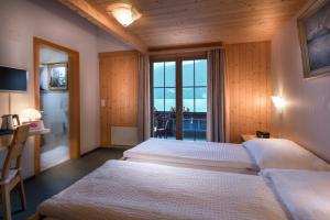 Postel nebo postele na pokoji v ubytování Hotel Wildbach Brienz