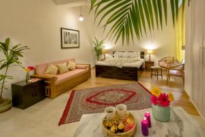 a living room with a couch and a bed at Hostie Tranquil Greens farmhouse near Golf course road Gurgaon in Gurgaon