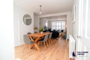 a dining room and living room with a table and chairs at Stylish Coastal 3 Bed Haven - Close to town in Salcombe