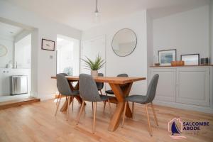 a dining room with a wooden table and chairs at Stylish Coastal 3 Bed Haven - Close to town in Salcombe