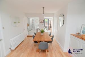 a dining room with a wooden table and chairs at Stylish Coastal 3 Bed Haven - Close to town in Salcombe