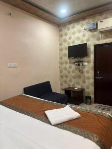 una stanza d'albergo con un letto e una sedia di Kashi residency palace a Varanasi