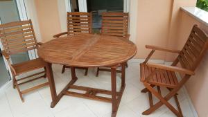 une table en bois et quatre chaises dans une chambre dans l'établissement Apartment Onbria Mar, à Medulin