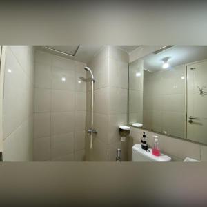 スラバヤにあるPAKUWON MALL Apartemen Orchard Anderson Tanglin Bensonのバスルーム(シャワー、トイレ、鏡付)