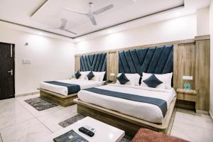 two beds in a hotel room with sidx sidx sidx sidx at Hotel The Katra Avenue in Katra