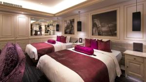 a hotel room with two beds with purple pillows at Hotel Piena Kobe in Kobe +282 photos