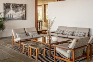 a living room with a couch and a table and chairs at Amalia Hotel Delphi in Delphi