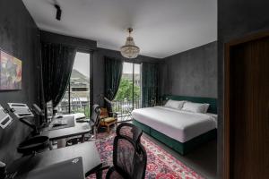 a hotel room with a bed and a desk with a desk at Boss Level Gaming Hotel in Rawai Beach