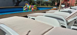 a swimming pool with white chairs and a slide at Owl's Nest in Bar