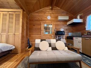 ein Wohnzimmer mit Couch und Küche in der Unterkunft コテージコッタロ in Gojikkoku