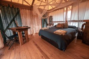 a bedroom with a bed and a table in a room at Slow Life Camping Venta del Moro in Venta del Moro +82 photos