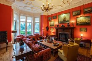 a living room with red walls and a fireplace at Penninghame Estate - Tower Apartment in Challoch +13 photos