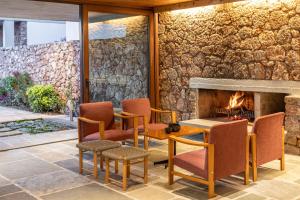 a patio with a stone wall and a fireplace at Amalia Hotel Delphi in Delphi