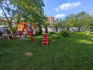 a playground with a red ladder in the grass at Villa Hills in Sarajevo
